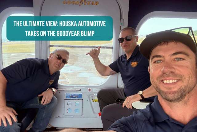 Thre individuals smiling for a selfie inside a blimp featuring the title 'the ultimate view:Houska Automotive Takes on the GoodYear Blimp